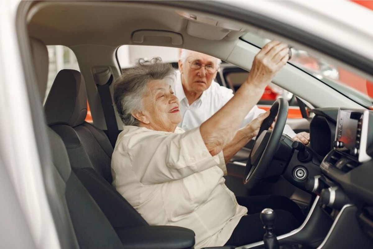 Uma idosa dirigindo seu carro após se atualizar sobre a notícia para Idosos com mais de 60 anos que têm CNH