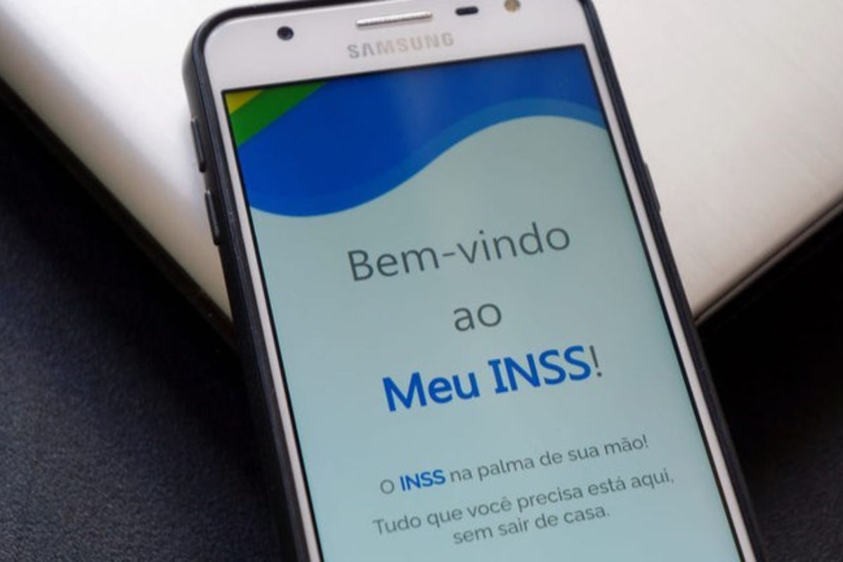 INSS Revoluciona e uma pessoa confere o seu aplicativo do INSS em um celular da Samsung