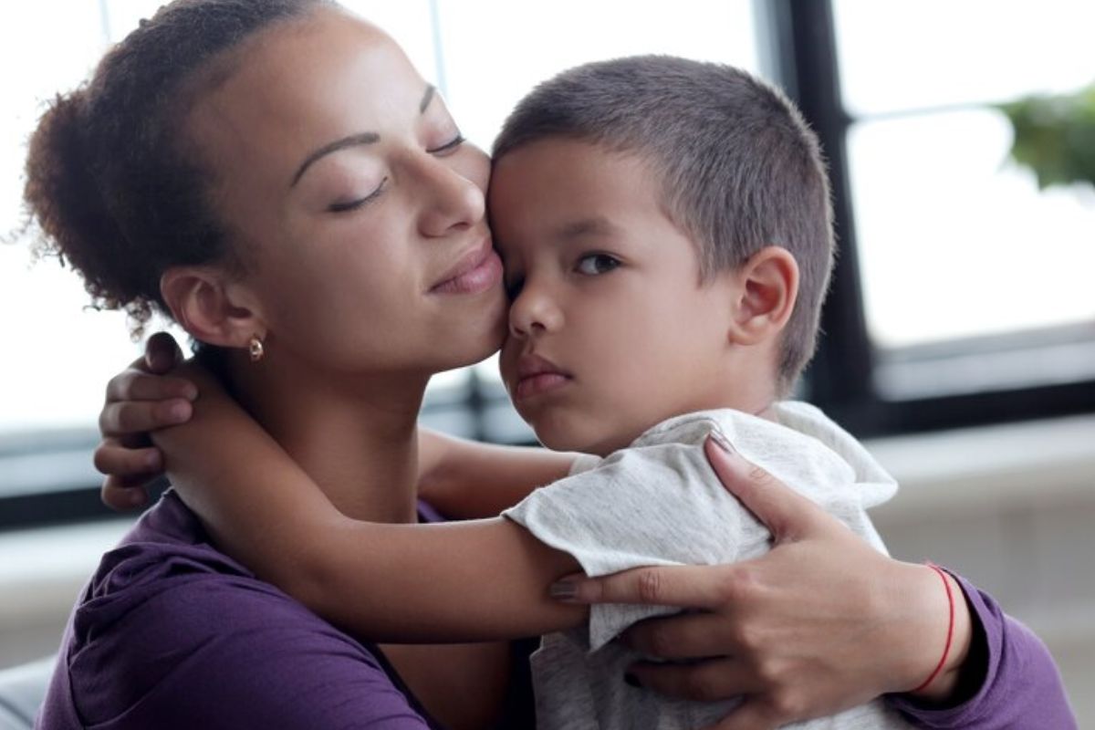 Uma mãe sorri com seu bebê no colo após ver que Mães Solteiras Receberão Benefício R$ 200