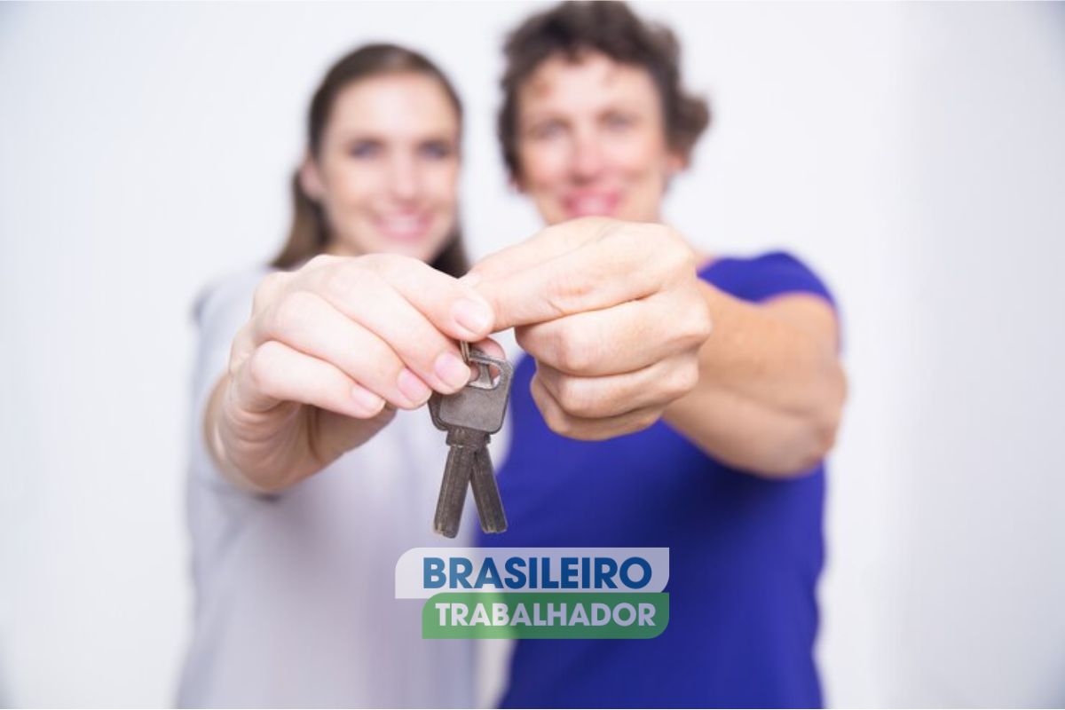 um casal segurando a chave de uma casa após ver os terrenos gratuitos para brasileiros