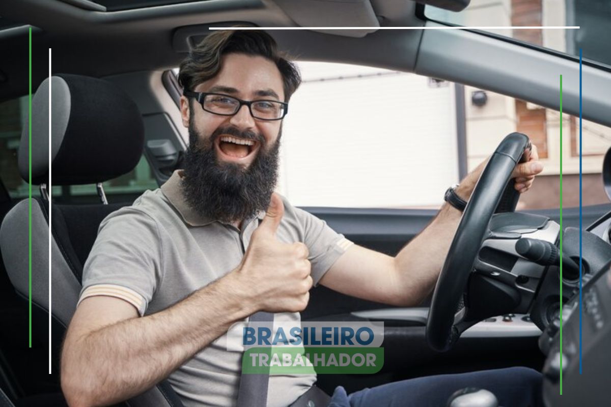 No carro, um dos Motoristas isentos faz sinal de positivo enquanto sorri em frente ao volante